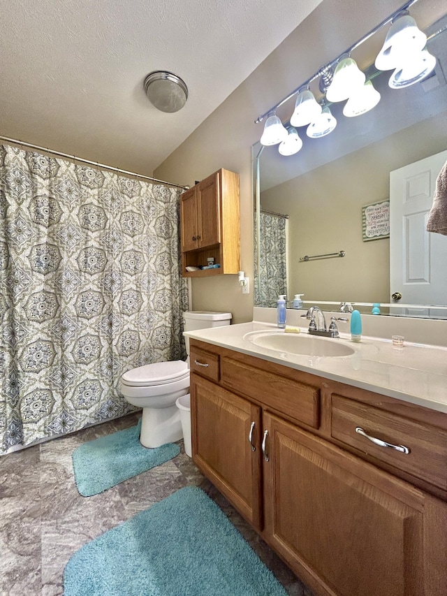 bathroom featuring vanity, a textured ceiling, and toilet