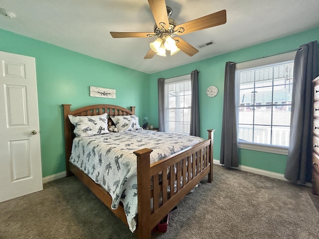 carpeted bedroom with multiple windows and ceiling fan