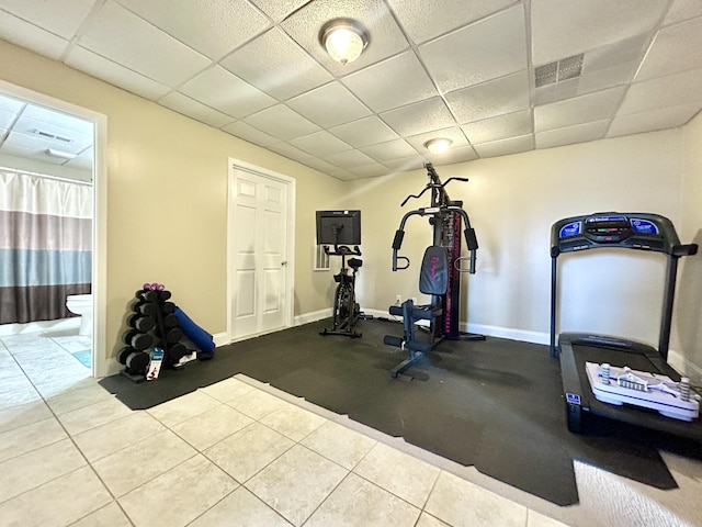 exercise room featuring a drop ceiling and tile patterned floors