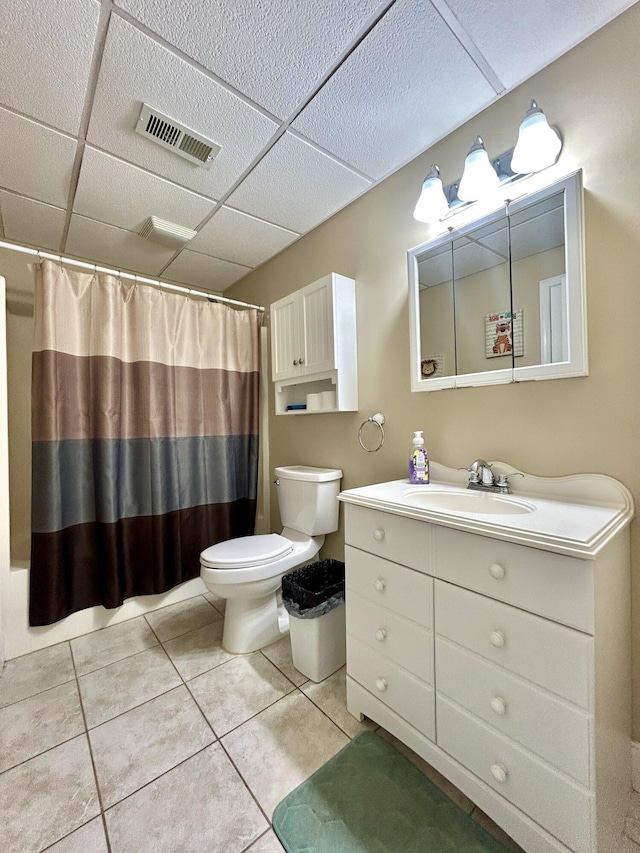 bathroom featuring tile patterned flooring, vanity, toilet, a drop ceiling, and a shower with shower curtain