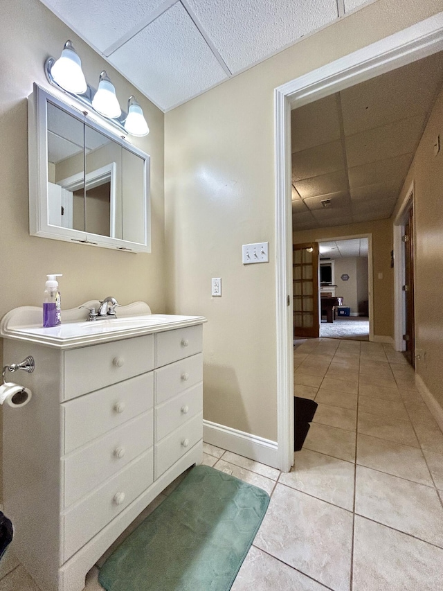 bathroom featuring vanity, tile patterned flooring, and a drop ceiling