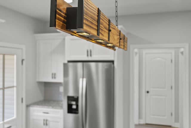 204 Max Cavnes Rd, Danville, KY 40422 - kitchen with light stone counters, hanging light fixtures, white cabinetry, and stainless steel fridge with ice dispenser