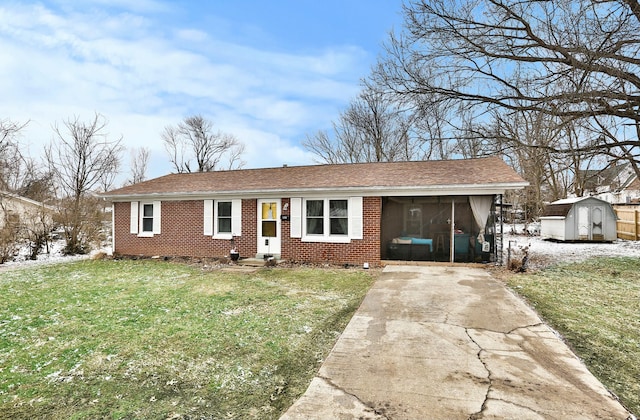 view of front of home with a sunroom, a storage unit, a front lawn, and brick siding