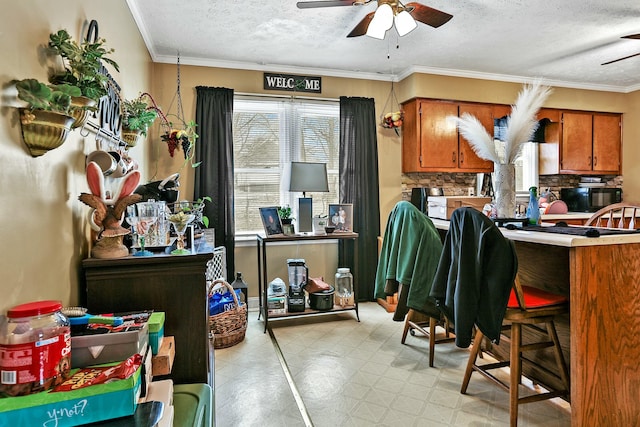 kitchen with light floors, crown molding, black microwave, and a ceiling fan