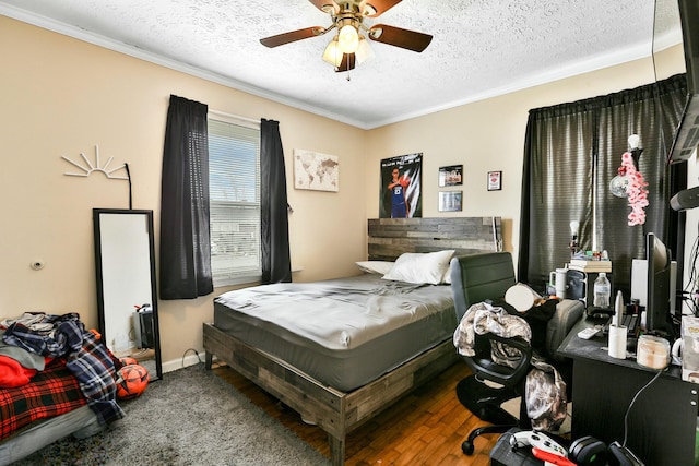 bedroom featuring baseboards, ceiling fan, wood finished floors, crown molding, and a textured ceiling