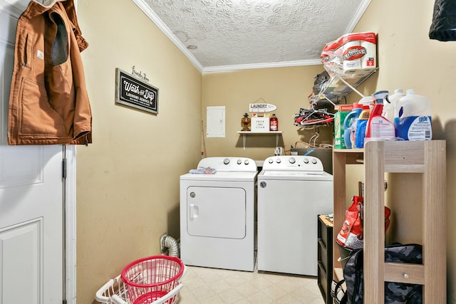 clothes washing area featuring laundry area, light floors, washing machine and clothes dryer, and crown molding