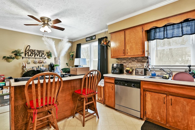 kitchen with light countertops, dishwasher, light floors, brown cabinetry, and crown molding