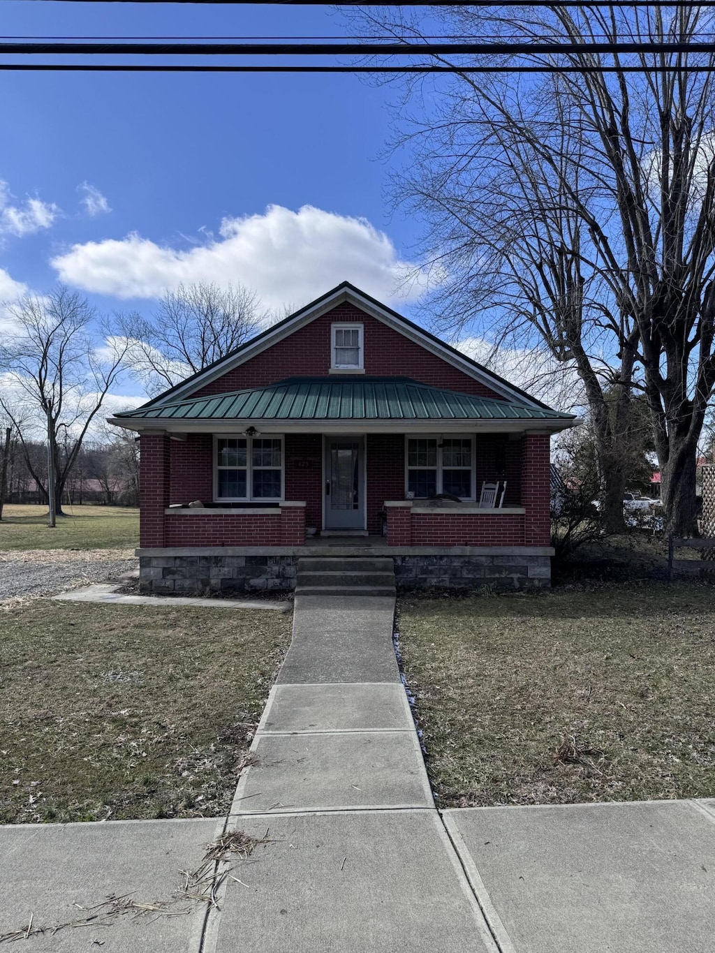 bungalow-style house featuring a front yard and covered porch