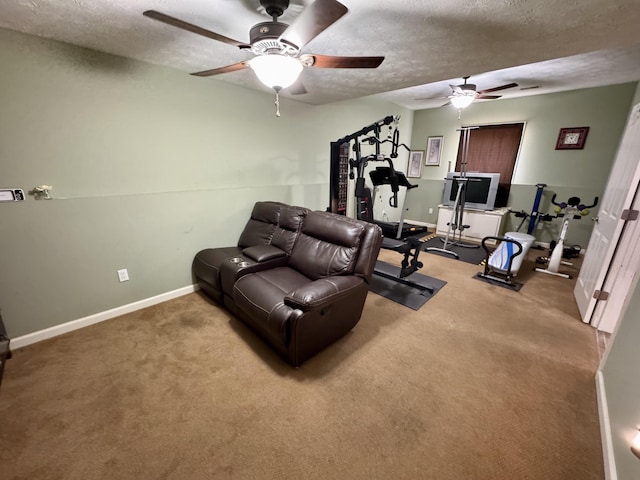 workout area with a textured ceiling, carpet floors, a ceiling fan, and baseboards