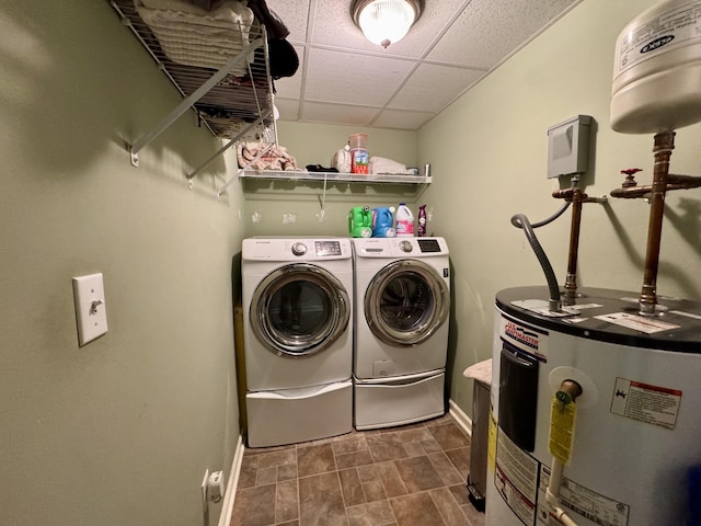 clothes washing area featuring laundry area, washing machine and dryer, baseboards, and electric water heater