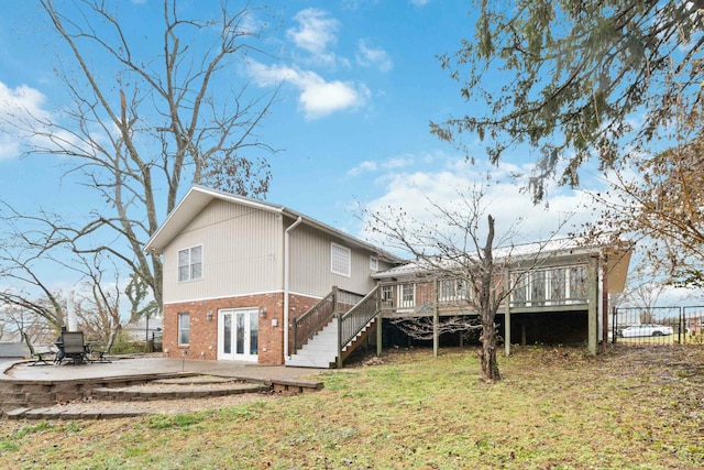 back of house with french doors, a deck, a patio area, and a lawn