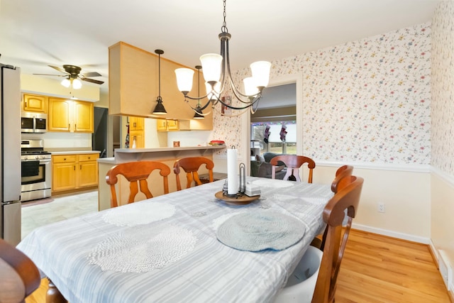 dining area with ceiling fan with notable chandelier and light wood-type flooring