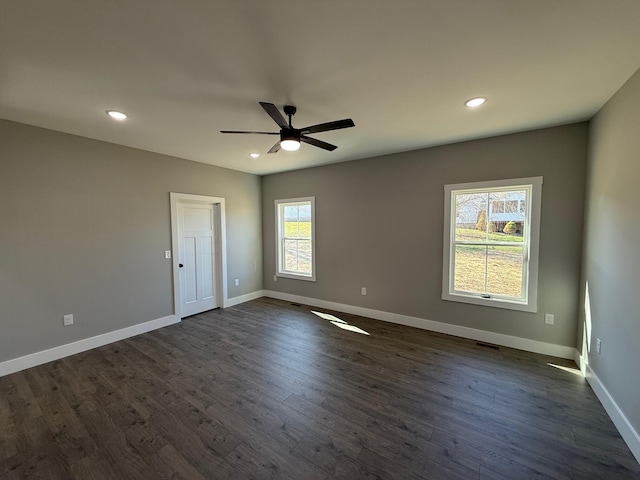 spare room with dark hardwood / wood-style flooring and ceiling fan