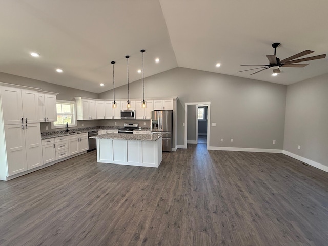 kitchen with a kitchen island, pendant lighting, white cabinetry, light stone counters, and stainless steel appliances