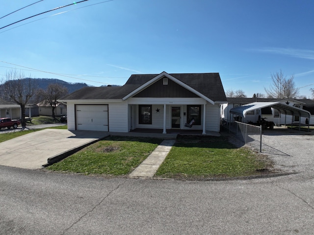 view of front of house with concrete driveway, covered porch, an attached garage, fence, and a front lawn