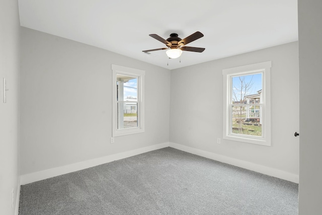 carpeted empty room with ceiling fan and baseboards