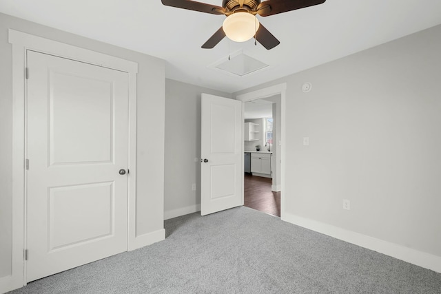 unfurnished bedroom featuring carpet floors, attic access, ceiling fan, and baseboards