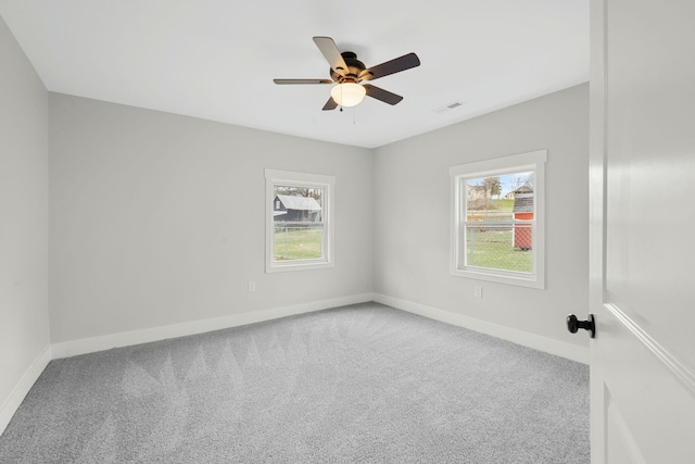 carpeted empty room with visible vents, plenty of natural light, and baseboards