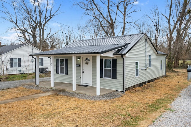 bungalow-style house with a porch, central AC, and metal roof