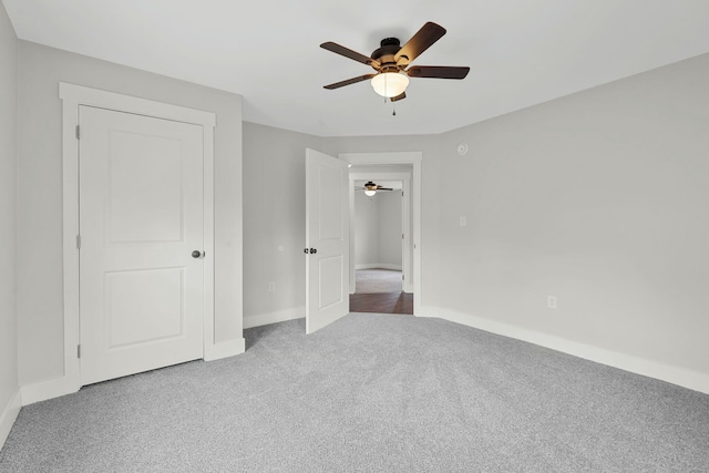 unfurnished bedroom with carpet floors, baseboards, and a ceiling fan