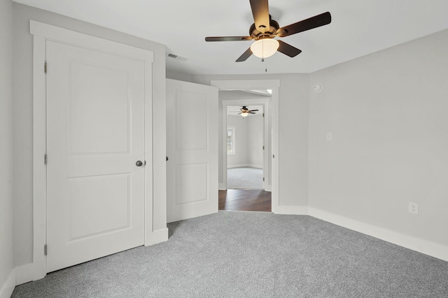 unfurnished bedroom with ceiling fan, carpet, visible vents, and baseboards