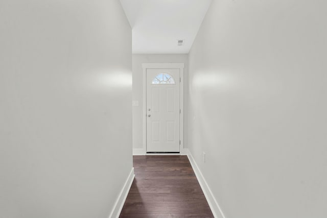 doorway to outside with dark wood-style floors, visible vents, and baseboards