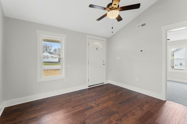 foyer entrance with dark wood-style floors, visible vents, vaulted ceiling, ceiling fan, and baseboards