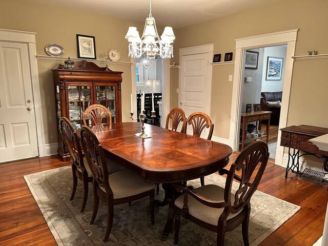 dining room with baseboards, dark wood-type flooring, and an inviting chandelier