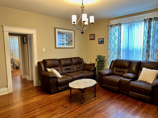 living area featuring dark wood-style floors and an inviting chandelier