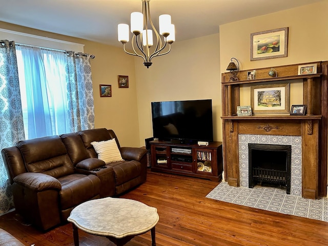 living room featuring a notable chandelier, wood finished floors, and a tile fireplace