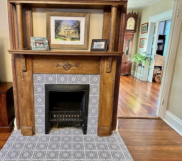 room details with a fireplace, wood finished floors, and baseboards