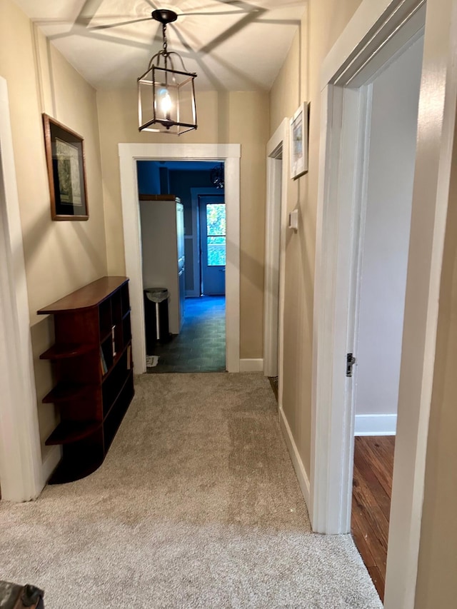 corridor with carpet flooring and baseboards