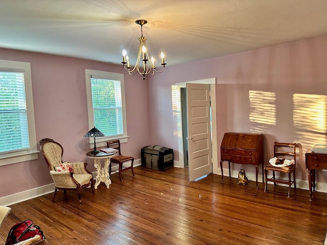 sitting room featuring baseboards, dark wood finished floors, and a notable chandelier