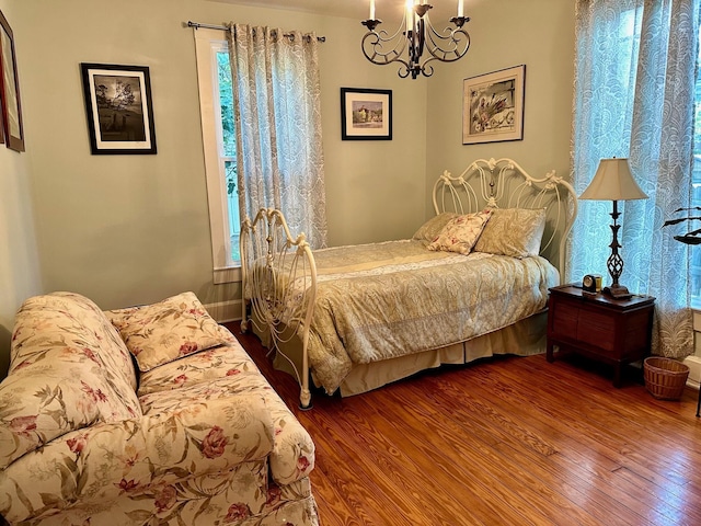 bedroom with an inviting chandelier and wood finished floors