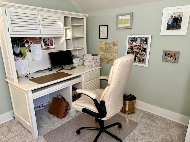 office space featuring light colored carpet, vaulted ceiling, and baseboards