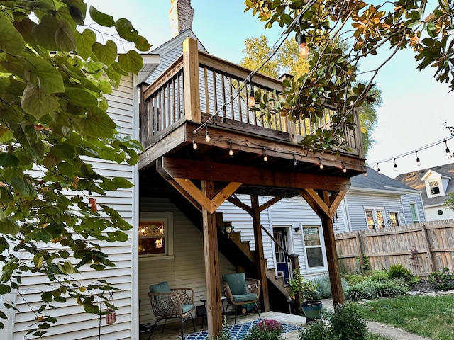 back of property with fence and a balcony