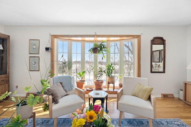 sitting room with visible vents, baseboards, and wood finished floors