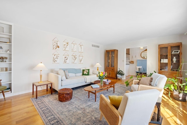 living room with light wood-style floors and visible vents