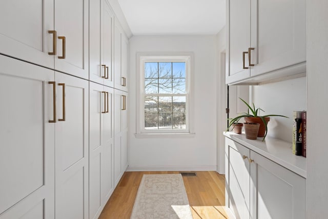 entryway featuring light wood-style flooring, visible vents, and baseboards