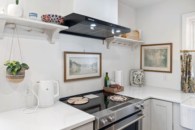 kitchen with range hood, electric stove, light countertops, and open shelves