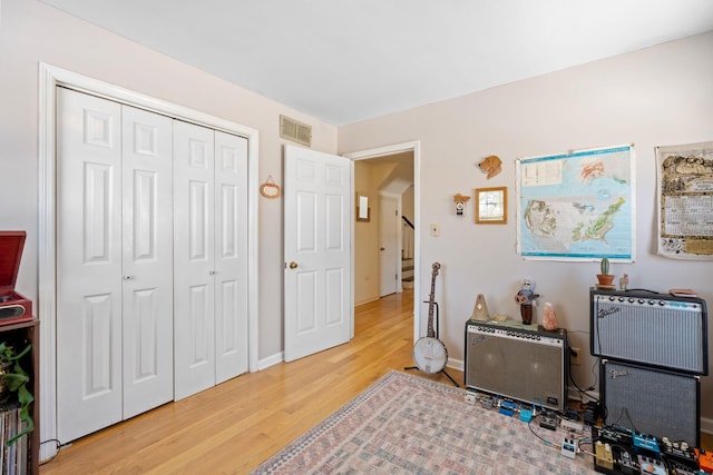 rec room with visible vents, baseboards, and wood finished floors