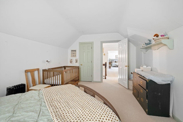 bedroom with vaulted ceiling and light colored carpet