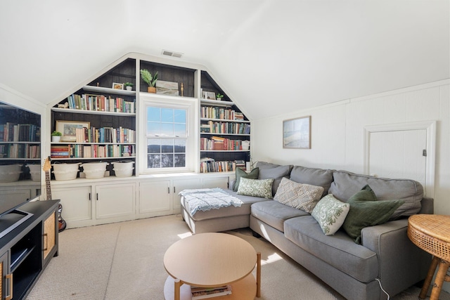 living area with lofted ceiling, built in features, visible vents, and light colored carpet