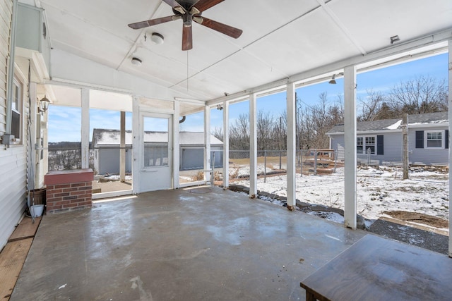 unfurnished sunroom featuring plenty of natural light and a ceiling fan