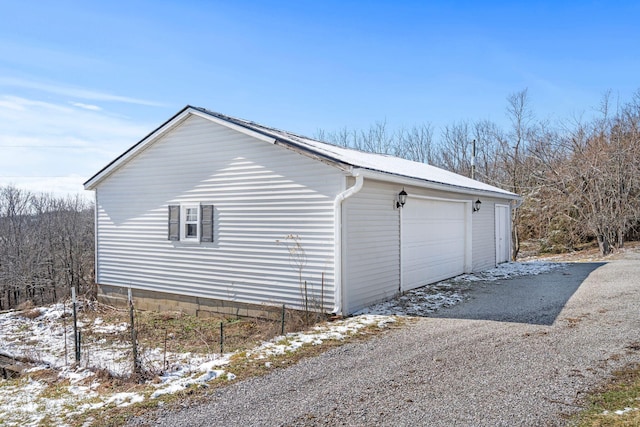 snow covered garage featuring a garage