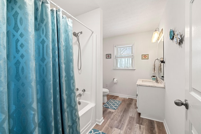 full bathroom with hardwood / wood-style flooring, toilet, shower / tub combo, a textured ceiling, and vanity