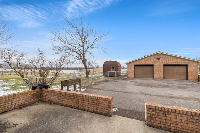 exterior space with a water view, an outdoor structure, and a garage