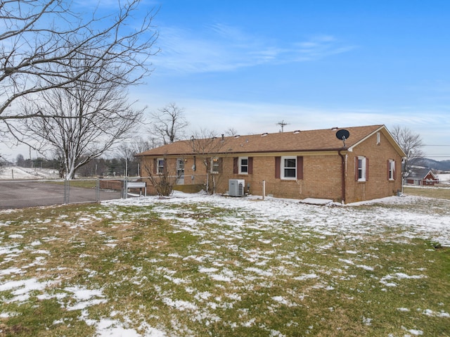 snow covered rear of property featuring cooling unit