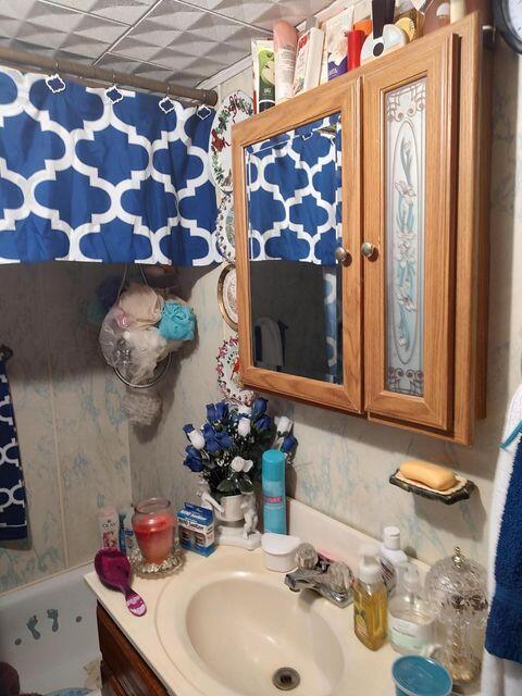 bathroom with vanity and wallpapered walls