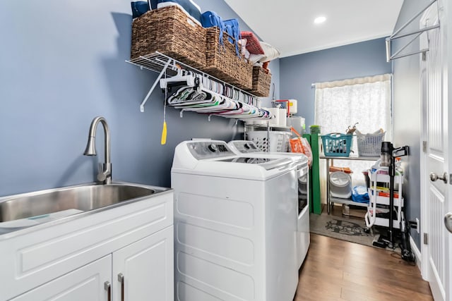 laundry room featuring cabinets, sink, separate washer and dryer, and light wood-type flooring